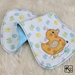 Baby burping cloth made with soft flannel rubber ducky design and accented with an embroidered rubber duck and detail stitching all through the edge.