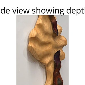 May include: Side view of a wooden sculpture with a textured surface. The sculpture is painted in shades of brown and has a metallic, iridescent accent.