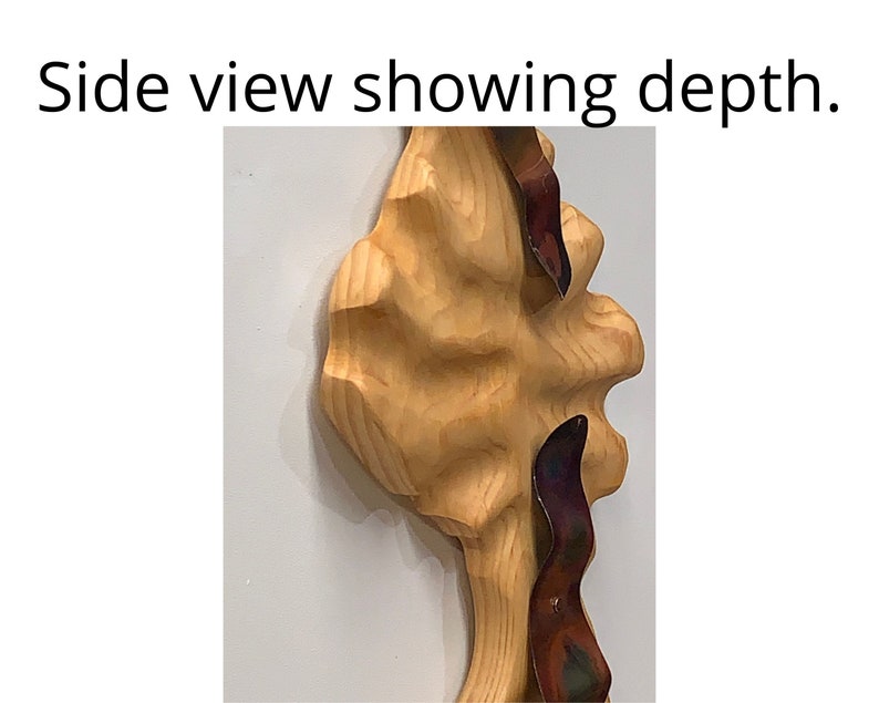 May include: Side view of a wooden sculpture with a textured surface. The sculpture is painted in shades of brown and has a metallic, iridescent accent.