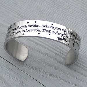 May include: A silver bracelet with a quote engraved on it: "Between sleep & awake... where you can still remember where I'll always love you. That's where I'll be waiting."