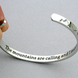 May include: Silver bracelet with the inscription "The mountains are calling and I must go".