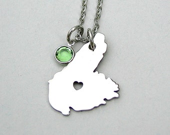 May include: A silver necklace with a heart-shaped cutout of the state of Maine and a light green gemstone charm.