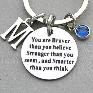 May include: Silver keychain with a blue rhinestone charm and a round tag that reads "You are Braver than you believe Stronger than you seem, and Smarter than you think".