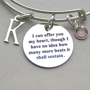 May include: A silver bangle bracelet with a charm that reads "I can offer you my heart, though I have no idea how many more beats it shall sustain."