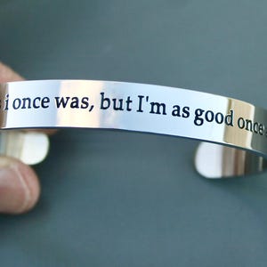 May include: A silver bracelet with the inscription "Not as I once was, but I'm as good once as I was".