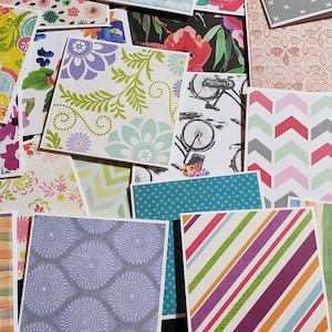May include: A collection of patterned paper squares in various colors and designs, including floral, geometric, and abstract patterns.