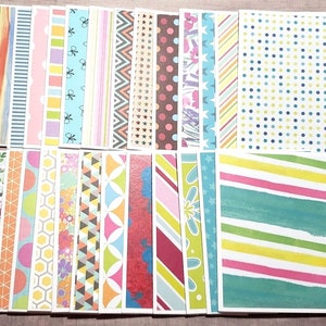 May include: A set of 24 patterned paper cards, each featuring a different design. The cards are rectangular and have a white border. The patterns include stripes, polka dots, geometric shapes, and floral designs. The colors are bright and cheerful, including pink, blue, green, yellow, and orange.
