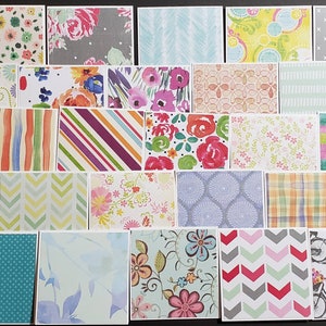 May include: A collection of 25 patterned paper cards, featuring a variety of designs, including floral, geometric, and abstract patterns. The cards are all different colors and sizes, and they are arranged in a grid pattern.