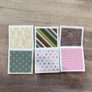 May include: Six square paper cards with various patterns. The patterns include fern leaves, diagonal stripes, floral designs, and polka dots. The color palette includes green, brown, pink, and yellow.
