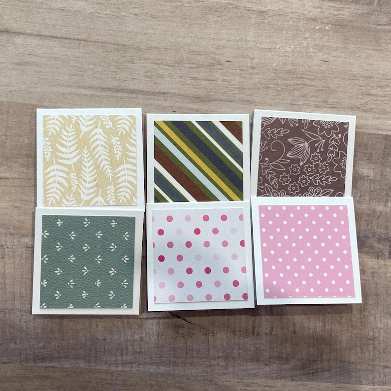 May include: Six square paper cards with various patterns. The patterns include fern leaves, diagonal stripes, floral designs, and polka dots. The color palette includes green, brown, pink, and yellow.