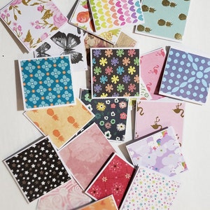 May include: A collection of colorful patterned paper cards with various designs, including hearts, stars, flowers, and geometric shapes. The cards are perfect for scrapbooking, card making, or other craft projects.