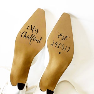 May include: A pair of white bridal shoes with the text "Mrs Chalfont" and "Est 24.08.19" written on the soles.
