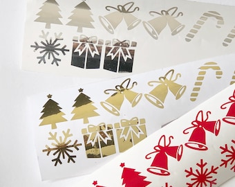 May include: Three sheets of stickers with a Christmas theme. The first sheet has silver snowflake, Christmas tree, bell, and gift box stickers. The second sheet has gold snowflake, Christmas tree, bell, and gift box stickers. The third sheet has red snowflake, Christmas tree, bell, candy cane, and gift box stickers.