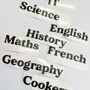 Könnte beinhalten: Weißes Papier mit schwarzen Textetiketten für verschiedene Schulfächer, darunter IT, Naturwissenschaften, Englisch, Geschichte, Französisch, Mathematik, Geographie und Kochen.