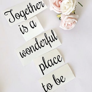 May include: Four white vinyl stickers with black cursive text that reads "Together is a wonderful place to be".