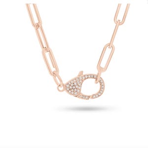 May include: A rose gold chain necklace with a pave diamond clasp. The chain is made of linked rectangles.