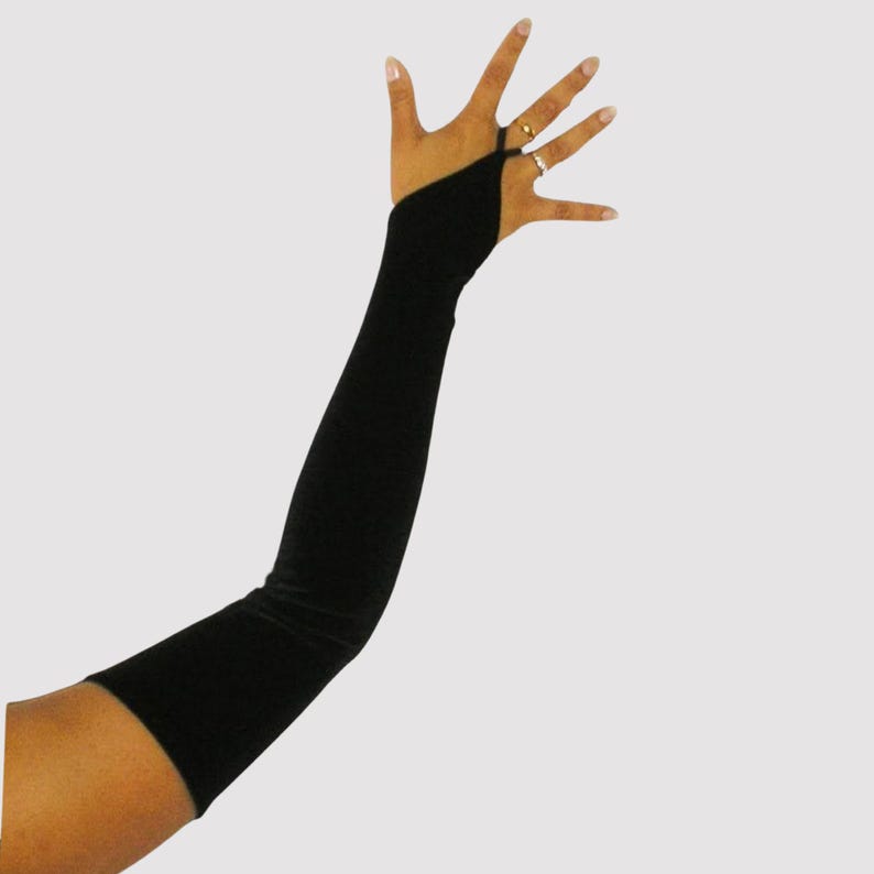 Long black stretch velvet fingerless gloves which are pointed over the hand with an elasticated loop to go overthe middle finger. The gloves reach approximately a few inches above the elbow.