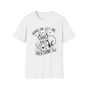 Puede incluir: Camiseta blanca con una ilustración en blanco y negro de una ardilla con gafas sosteniendo una taza de café. El texto "Hang on, let me overthink this" está arriba y abajo de la ardilla.