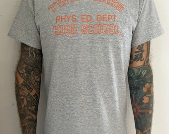 May include: Gray t-shirt with an orange graphic that reads "Twin Peaks Phys. Ed. Dept. High School"