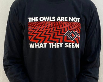 May include: Black long-sleeve t-shirt with a red and black graphic of a zig-zag pattern and the text "The Owls Are Not What They Seem".