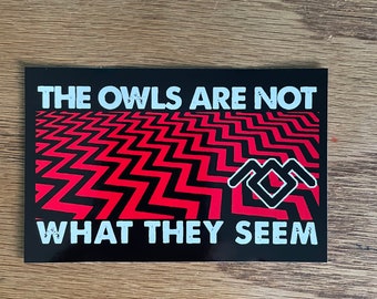 May include: Black and red sticker with the text "The owls are not what they seem" and a black and white owl symbol. The background is a red and black zig-zag pattern.