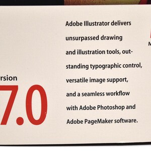 May include: A white box with red text that reads "version 7.0". The box also has black text that reads "Adobe Illustrator delivers unsurpassed drawing and illustration tools, outstanding typographic control, versatile image support, and a seamless workflow with Adobe Photoshop and Adobe PageMaker software." The box also has a red "M" with the text "Macintosh" below it.