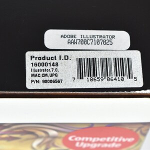 May include: A black box with a white label that says "Adobe Illustrator AAW700C7107025". The label also includes the product ID "16000148", the software version "Illustrator, 7.0", the platform "MAC.CM, UPG", and the part number "90006567". The label also includes a barcode.