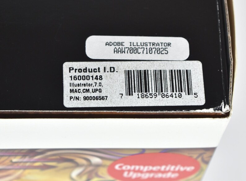 May include: A black box with a white label that says "Adobe Illustrator AAW700C7107025". The label also includes the product ID "16000148", the software version "Illustrator, 7.0", the platform "MAC.CM, UPG", and the part number "90006567". The label also includes a barcode.