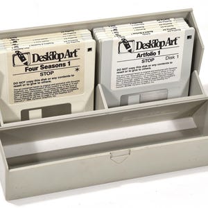 May include: A gray plastic storage case holding two stacks of 5.25-inch floppy disks. The disks are labeled "Desktop Art" with titles like "Four Seasons 1" and "Artfolio 1." Each disk has a warning: "DO NOT copy this disk or any contents to resell or to give to others."