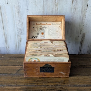 Caja de recetas de harina Gold Medal con recetas, separadores originales, archivador de madera, tarjetas manuscritas y recortes, cocina vintage.