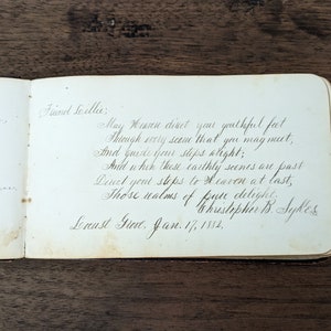 Pode incluir: Um poema escrito à mão em letra cursiva numa página de um livro. O poema diz: "Que o Céu dirija os teus pés jovens através de cada cena que possas encontrar, e guie os teus passos corretamente; e quando estas cenas terrenas tiverem passado, dirige os teus passos para o Céu no fim, esses reinos de puro deleite." O poema é assinado "Christopher B. Sykes" e datado de "17 de janeiro de 1882."