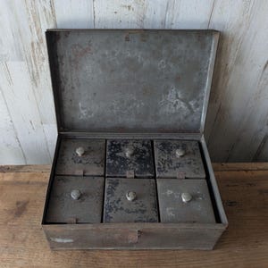 May include: A set of three ceramic nesting bowls in graduating sizes. The bowls feature a speckled, matte finish in shades of cream, light brown, and dark brown. The largest bowl measures approximately 8 inches in diameter.