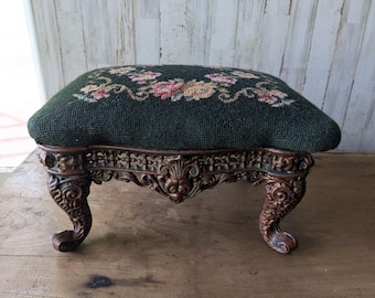 Taburete antiguo de punto de aguja, patas de hierro ornamentadas, reposapiés de tela original