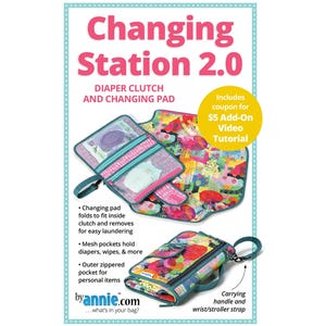 Op de afbeelding: Een Changing Station 2.0 luiertas en aankleedkussen set met een levendig, meerkleurig abstract bloemenpatroon. De set bevat een opvouwbaar kussen, een clutch met ritssluiting en mesh binnenzakken, en een draaghengsel met een polsband.