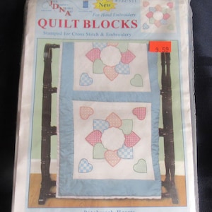 May include: A package of Jack Dempsey Needle Art quilt blocks, model #732-511, featuring Patchwork Hearts designs stamped for hand embroidery. The set includes six 18 inch by 18 inch cotton and polyester broadcloth blocks with heart patterns.