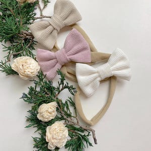 Puede incluir: Tres diademas de tela con lazos en beige, rosa y blanco. Las diademas est&aacute;n hechas de un material suave y el&aacute;stico y son perfectas para a&ntilde;adir un toque de estilo a cualquier atuendo.