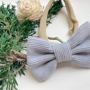 Puede incluir: Un lazo de pana gris claro atado a una diadema el&aacute;stica de color nude. La diadema es perfecta para beb&eacute;s y ni&ntilde;os peque&ntilde;os.