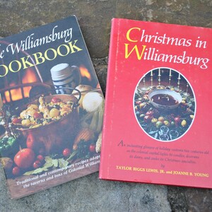 May include: Two vintage cookbooks with red and black covers. The first book is titled "The Williamsburg Cookbook" and features a copper pot with food inside. The second book is titled "Christmas in Williamsburg" and features a red bowl with a Christmas wreath around it.