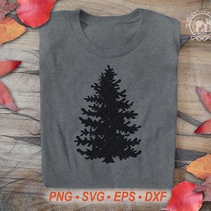 Puede incluir: Una camiseta gris con una silueta negra de un pino. La camiseta tiene cuello redondo y mangas cortas. La parte inferior de la imagen muestra el texto "PNG &bull; SVG &bull; EPS &bull; DXF". Hojas de oto&ntilde;o rojas y naranjas est&aacute;n esparcidas alrededor de la camiseta.