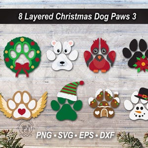 May include: A digital graphic set titled 8 Layered Christmas Dog Paws 3 featuring eight distinct paw print designs including a wreath, a polar bear, a cardinal, a poinsettia, angel wings, an elf hat, a gingerbread house, and a snowman.