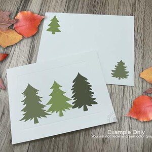 Puede incluir: Juego de papeler&iacute;a blanco con dise&ntilde;os de abetos verdes. El juego incluye una tarjeta con tres &aacute;rboles y un sobre con un solo &aacute;rbol. Hojas de oto&ntilde;o en tonos rojos, naranjas y amarillos rodean la papeler&iacute;a sobre una superficie de madera.