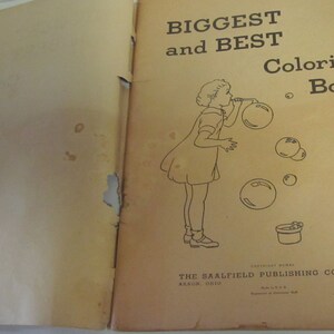 Puede incluir: Una portada de libro para colorear vintage con una ilustraci&oacute;n en blanco y negro de una ni&ntilde;a soplando burbujas. El texto de la portada dice "Biggest and Best Coloring Book" y "The Saalfield Publishing Company Akron, Ohio New York".