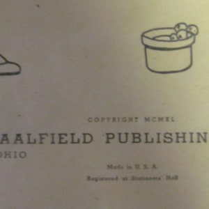 Puede incluir: Ilustraci&oacute;n en blanco y negro de un ni&ntilde;o con un vestido y zapatos, sosteniendo un cubo con bayas. El texto "COPYRIGHT MCMXL THE SAALFIELD PUBLISHING COMPA AKRON, OHIO Made in U.S.A. Registered at Stationers Hall NEW" est&aacute; impreso debajo de la ilustraci&oacute;n.