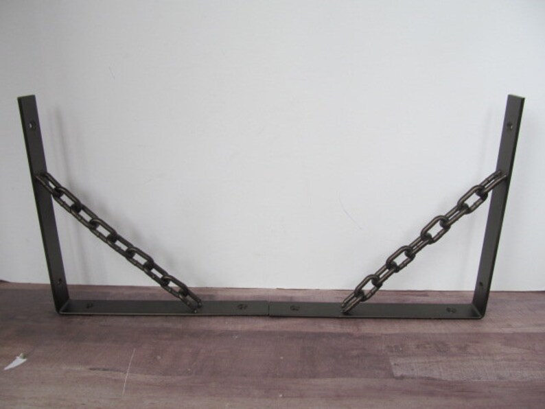May include: Two black metal shelf brackets with a chain connecting the two brackets.