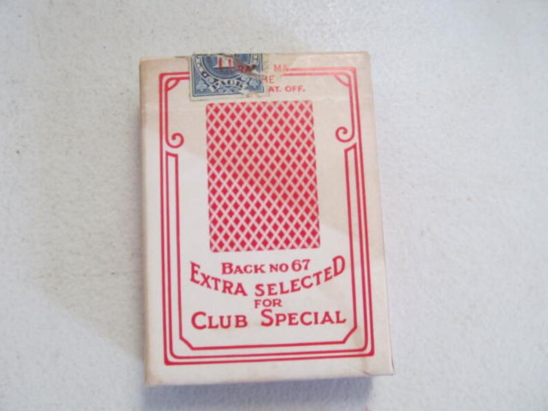 May include: A white box of playing cards with a red diamond pattern on the back. The box says "Back No 67 Extra Selected for Club Special".
