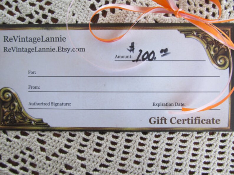 May include: A gift certificate for $100 from ReVintageLannie.Etsy.com. The certificate has a gold border and a ribbon.