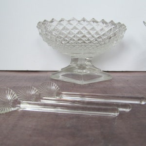 Puede incluir: Un juego de tres cucharas de vidrio transparente con un diseño de espiral decorativo. Las cucharas están dispuestas sobre una superficie de madera junto a un cuenco de vidrio transparente con un patrón de diamante.