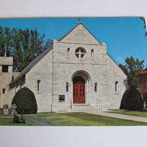 以下が含まれることがあります： 尖塔のある白い石造りの教会。教会の入り口はアーチ型で、入り口の上に十字架があり、ドアの上の丸い窓にも小さな十字架がある。