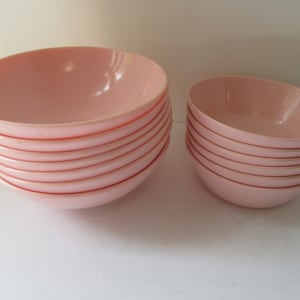 May include: A stack of ten pink plastic bowls. The bowls are nested together and are all the same size.