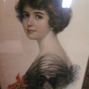 May include: A vintage portrait of a woman with dark hair wearing a black lace dress and a red poinsettia flower.